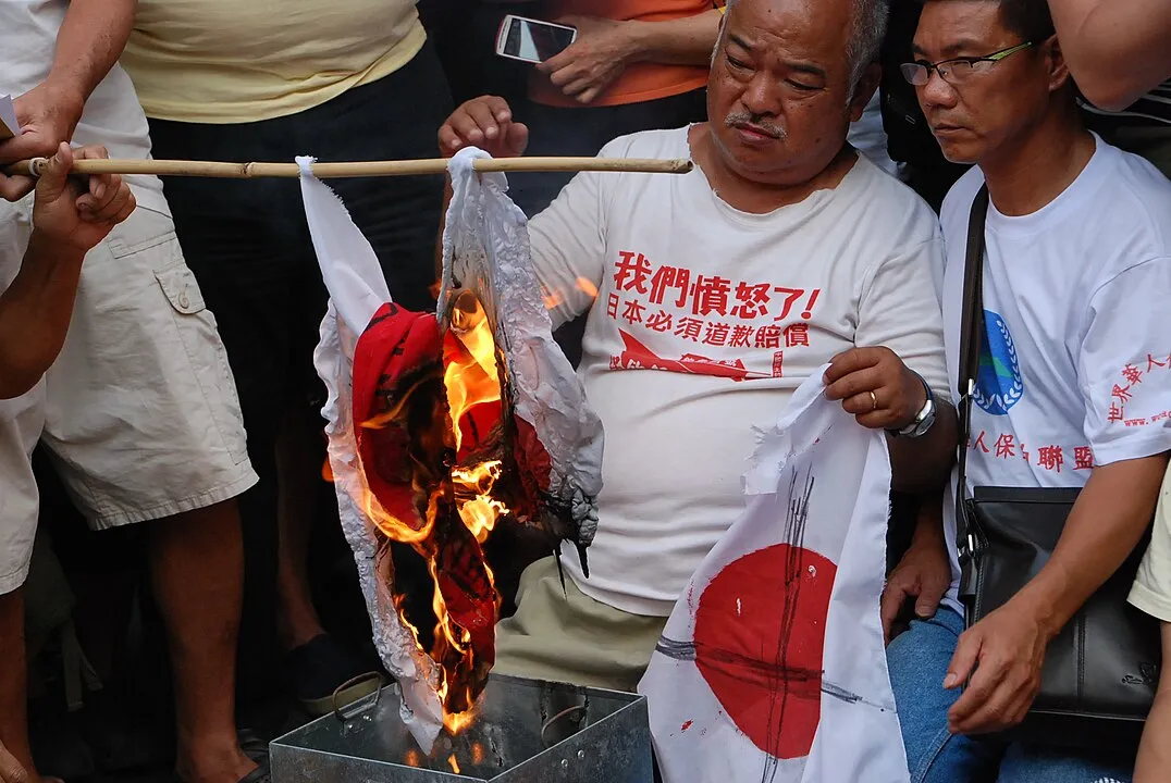 Protestors burn the Japanese national flag in front of Consulate-General of Japan in Hong Kong
