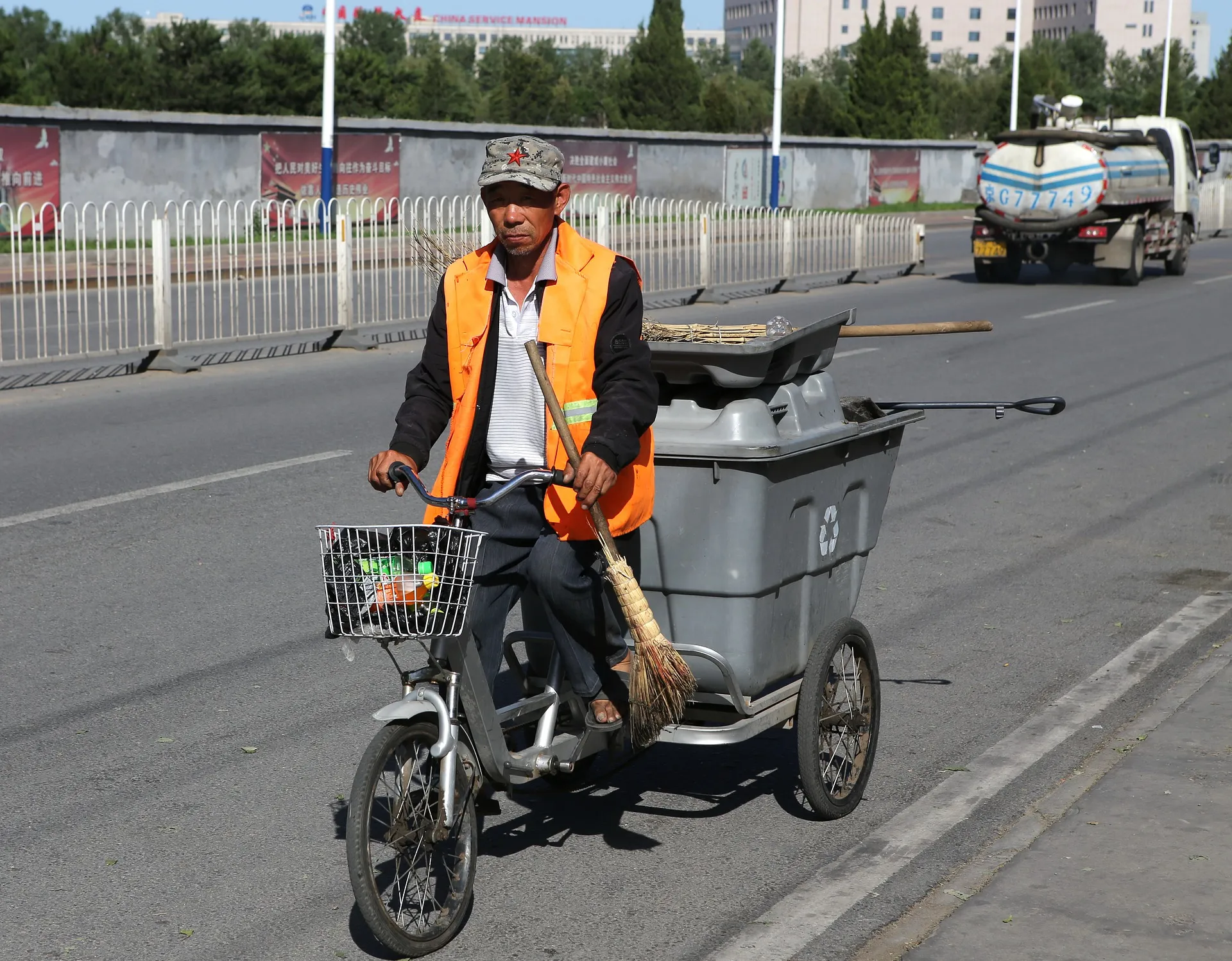 Chinese Man hauling trash with CCP hat on broken bike